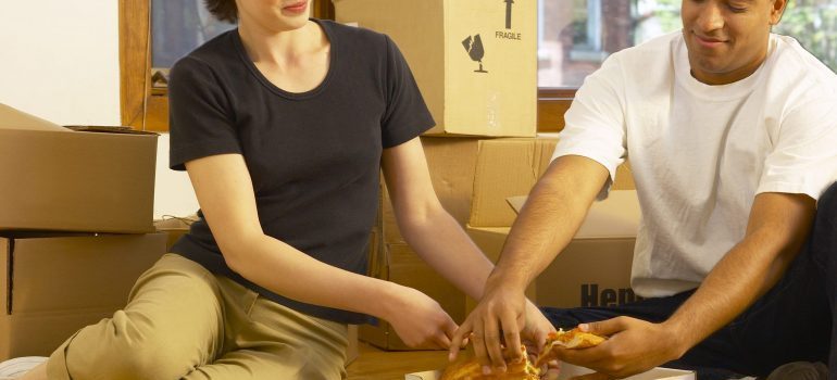 Couple eating pizza in new home