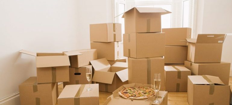 Pizza and champagne on moving boxes with movers Covina