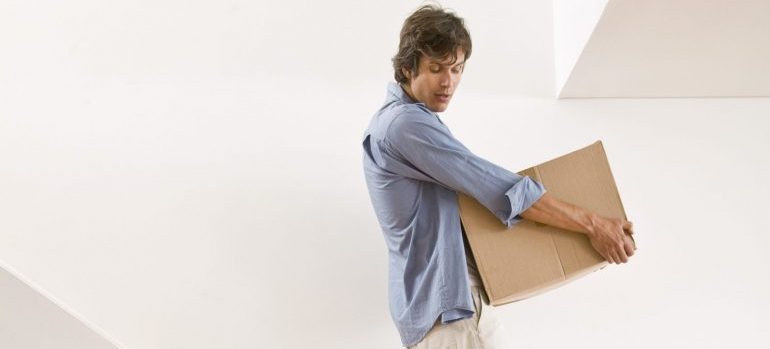 Man carrying moving box down stairs representing movers la verne ca