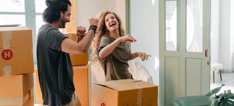 Couple packing boxes and dancing