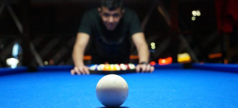Man playing pool and looking at the white ball