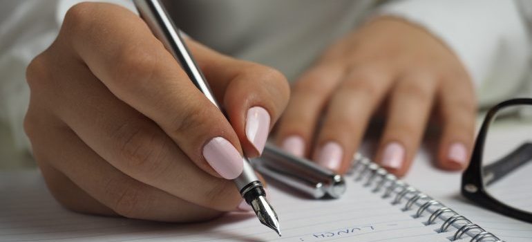 Woman writing down a list of pros and cons