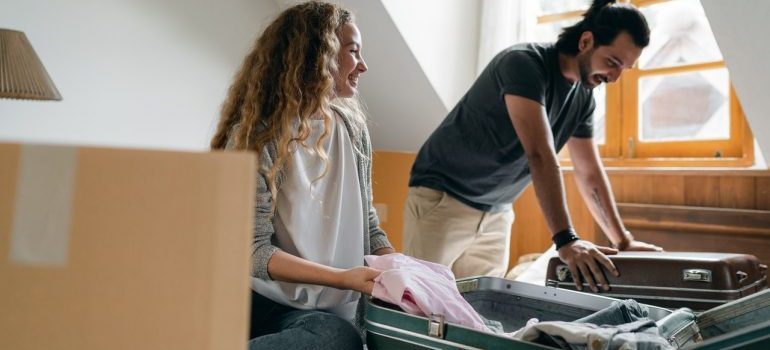 couple packing suitcases to save money on moving supplies