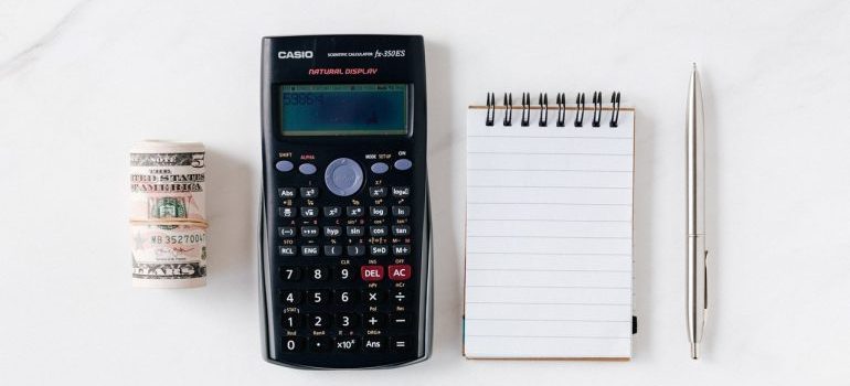 money, calculator, notebook, and a pen