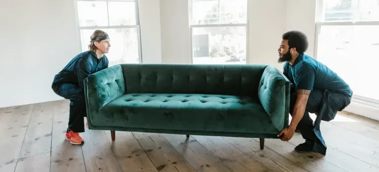 Two men carring a sofa