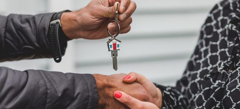 A person giving a house key to another person
