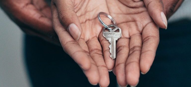 A person holding a key inside their palm
