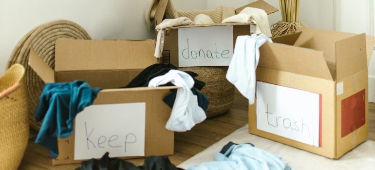 Boxes full of items, labeled to keep, donate and trash
