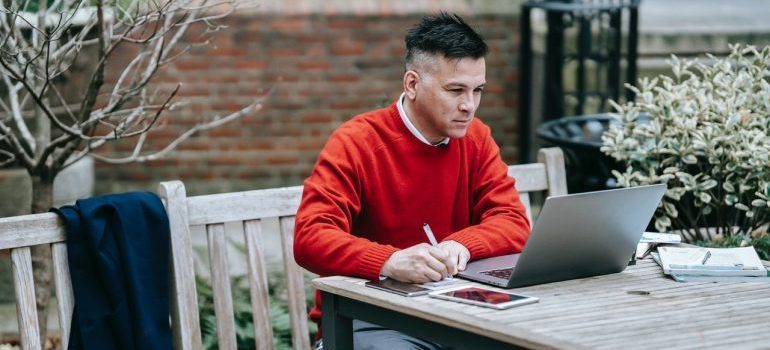 Man working on laptop and wondering whether to trust online moving reviews