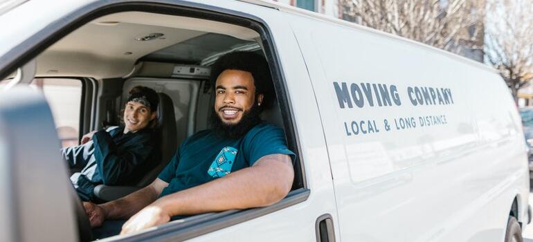 Two movers inside their moving truck