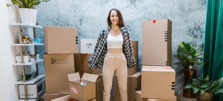 a woman standing next to boxes