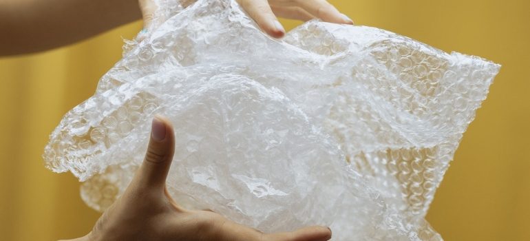 Person holding bubble wrap ready to pack and transport artwork