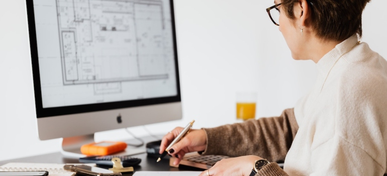 a woman looking at a floor plan in order to make a moving plan from scratch